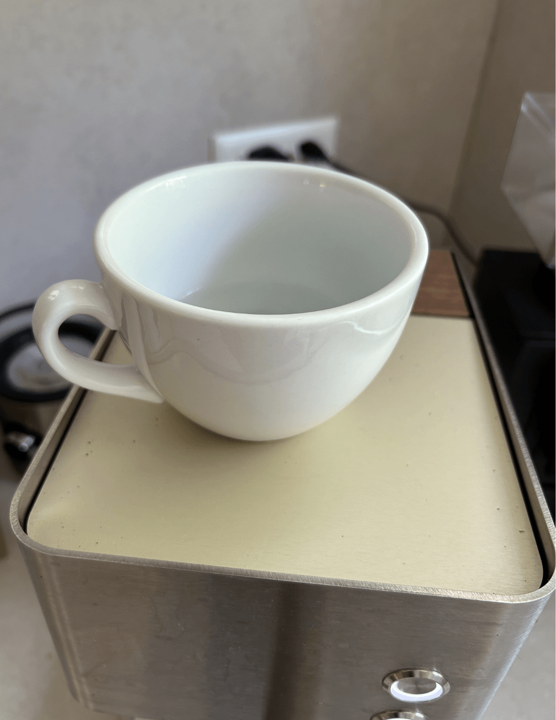 Espressotasse wird mit heißem Wasser auf der Zuriga vorgewärmt