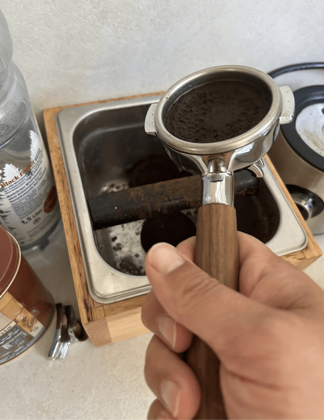Alter Kaffeepuck wird aus dem Siebträger in die Knock-Box ausgeklopft