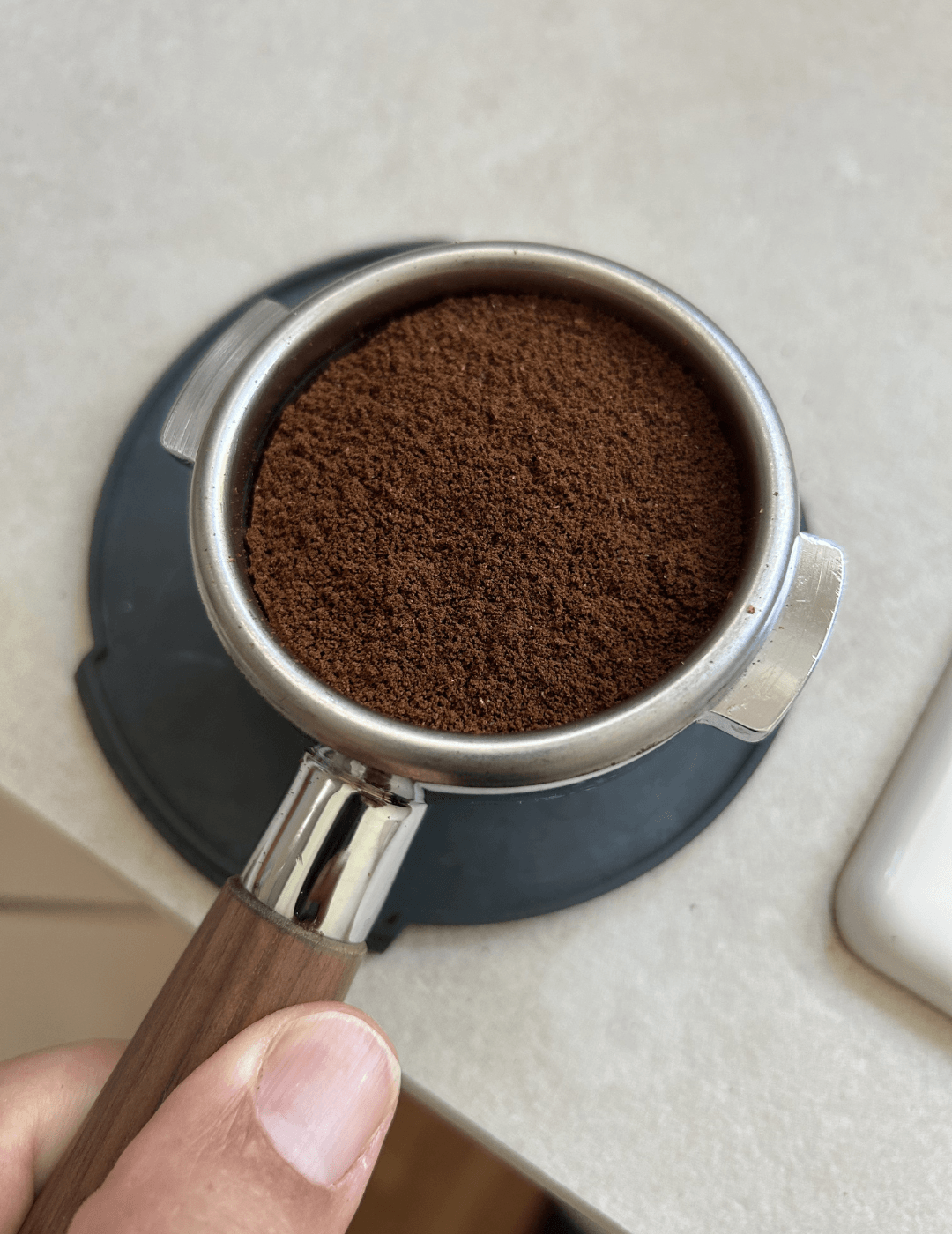 Frisch gemahlenes Kaffeemehl wird gleichmäßig im Siebträger verteilt