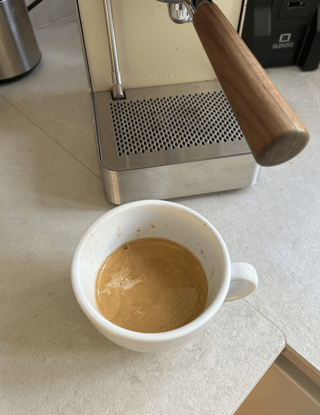 Frisch bezogener Espresso mit Crema in der Tasse unter dem Siebträger