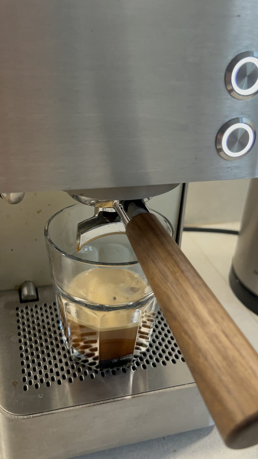 Doppelter Espresso läuft aus dem Siebträger in ein Glas
