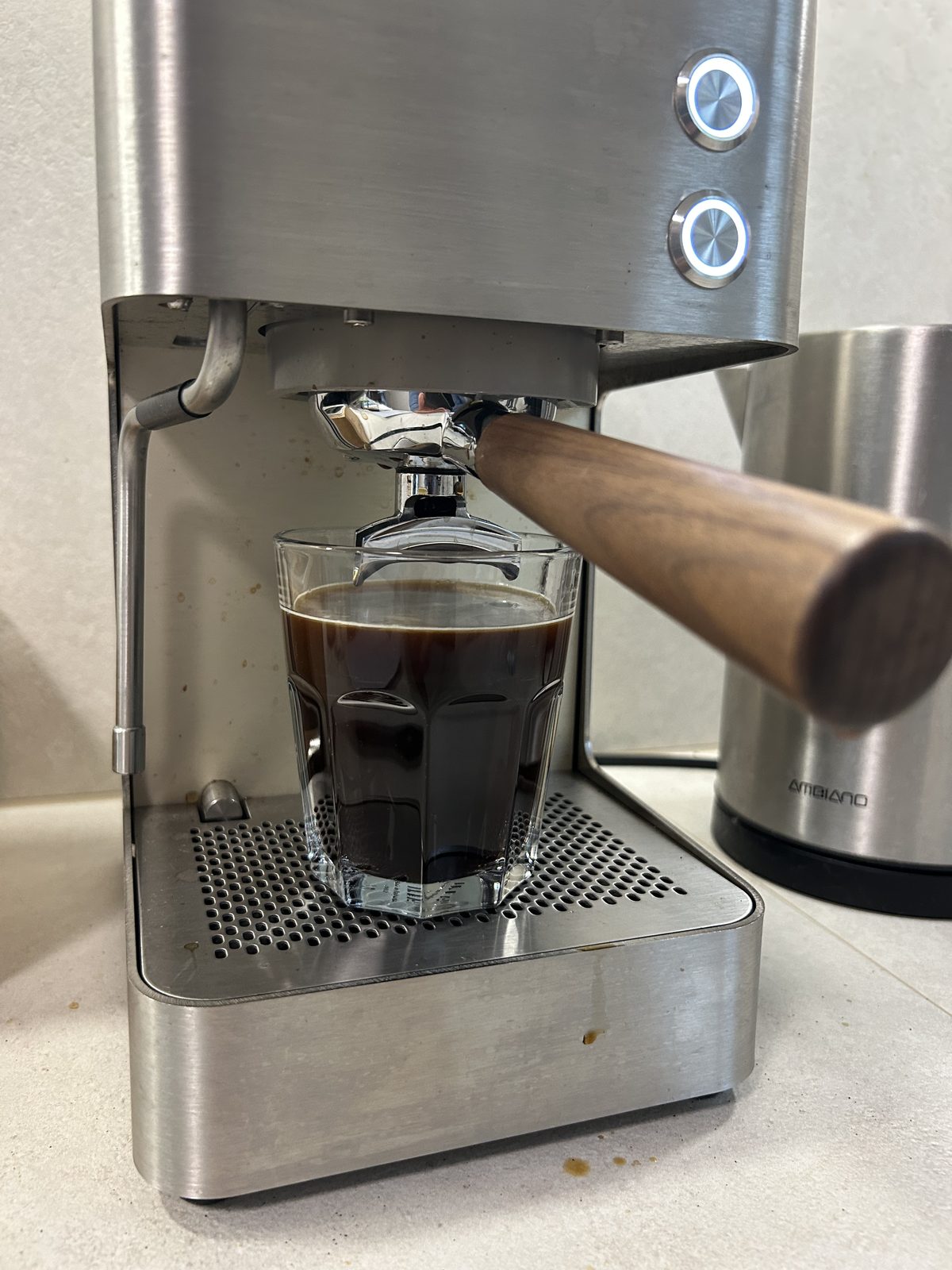 Long Black im Glas unter der Brühgruppe einer Siebträgermaschine