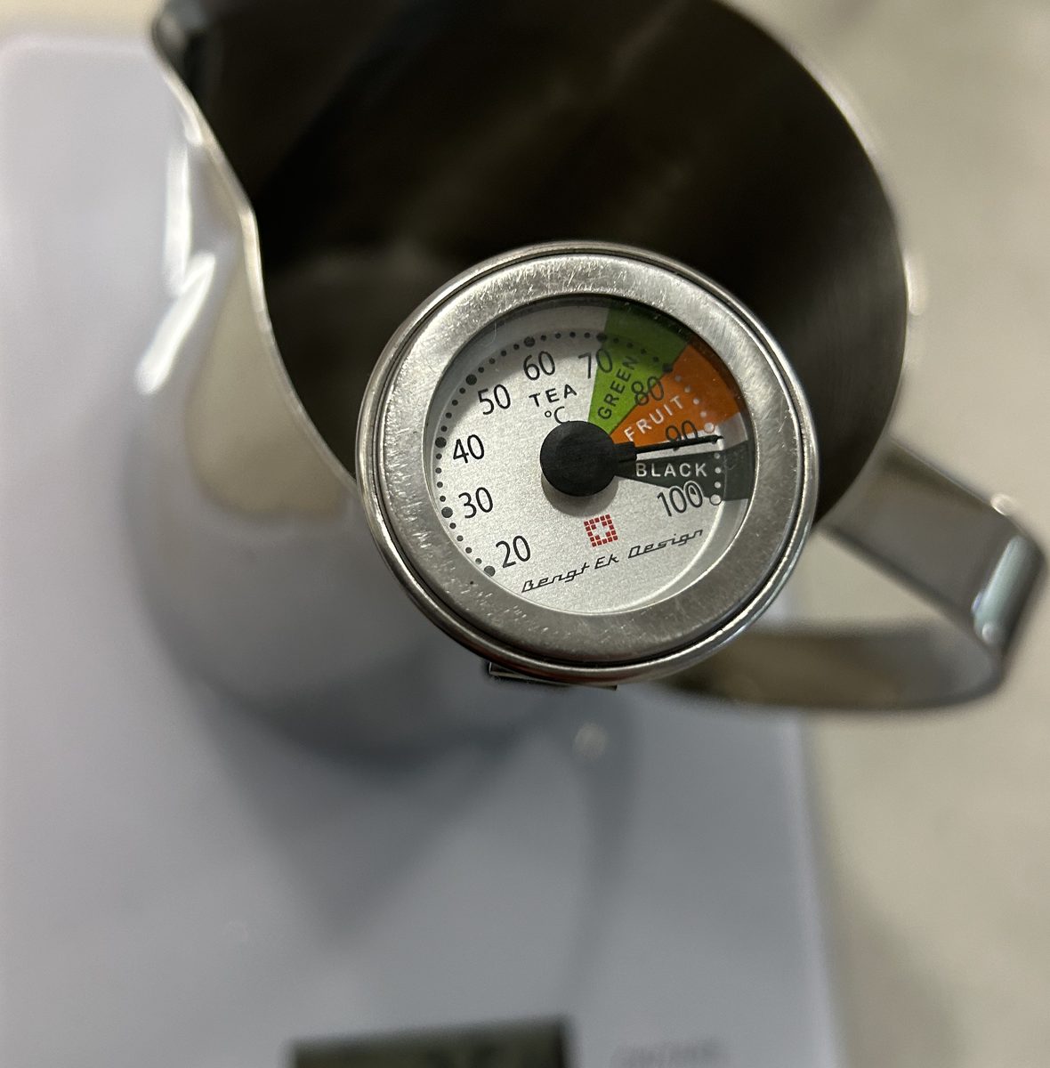Thermometer im Milchkännchen zeigt eine Wassertemperatur von knapp 90 Grad